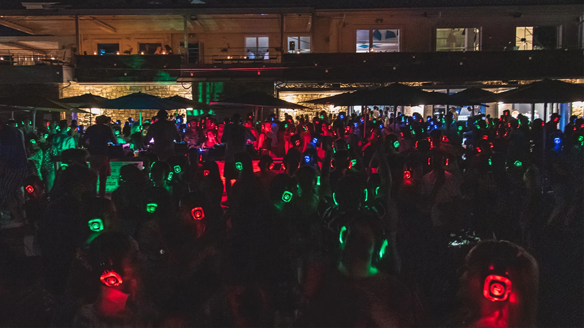 Silent party per universitari — persone ballano con cuffie illuminate